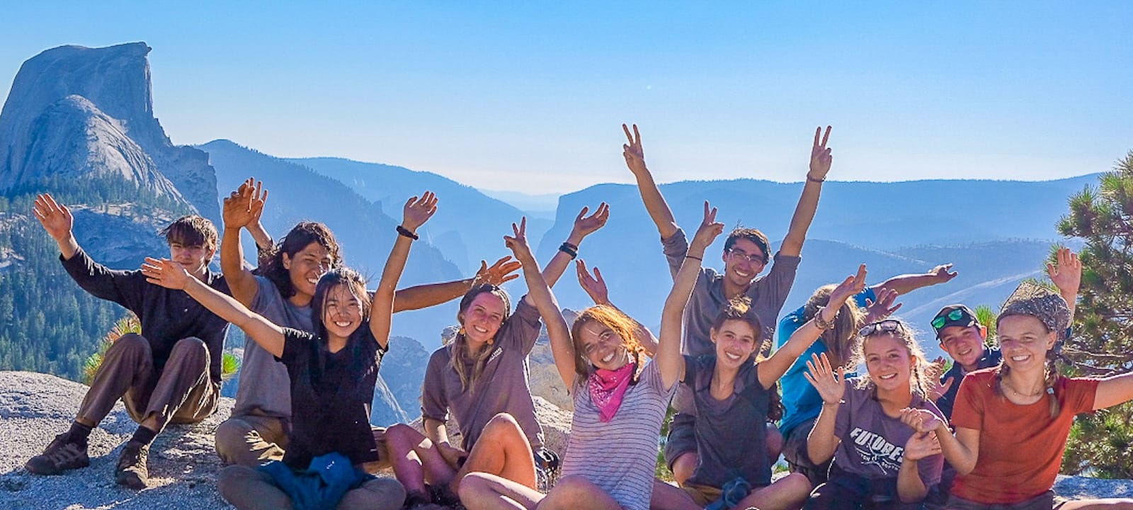 Teen backpackers on top of Clouds Rest with Half Dome in the background