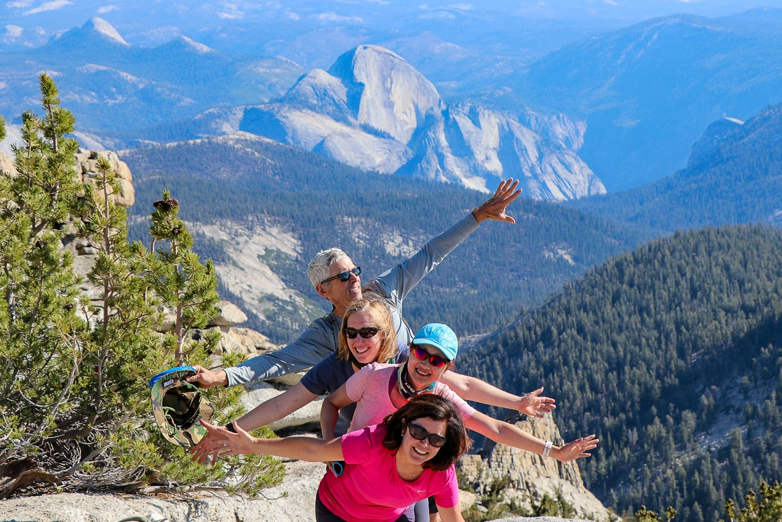 Four hikers on top of Mt Hoffmann with Half Dome in the background.