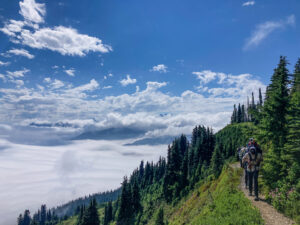 Backpackers on a trail above the clouds