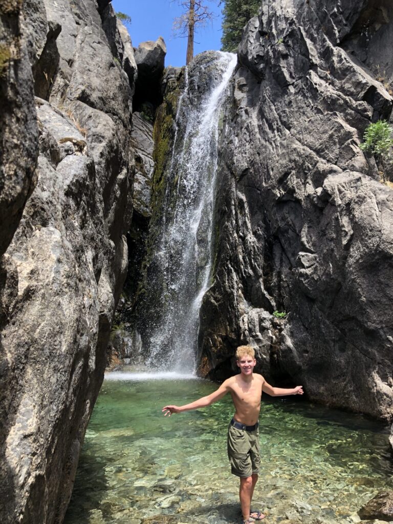Boy in front of waterfall