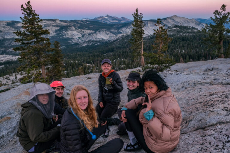 Young Women watching the sunset at May Lake bluff