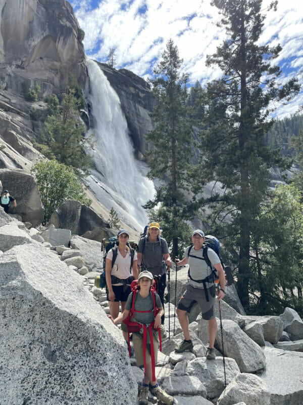A family poses in front of Nevada Fall on the Mist Trail.