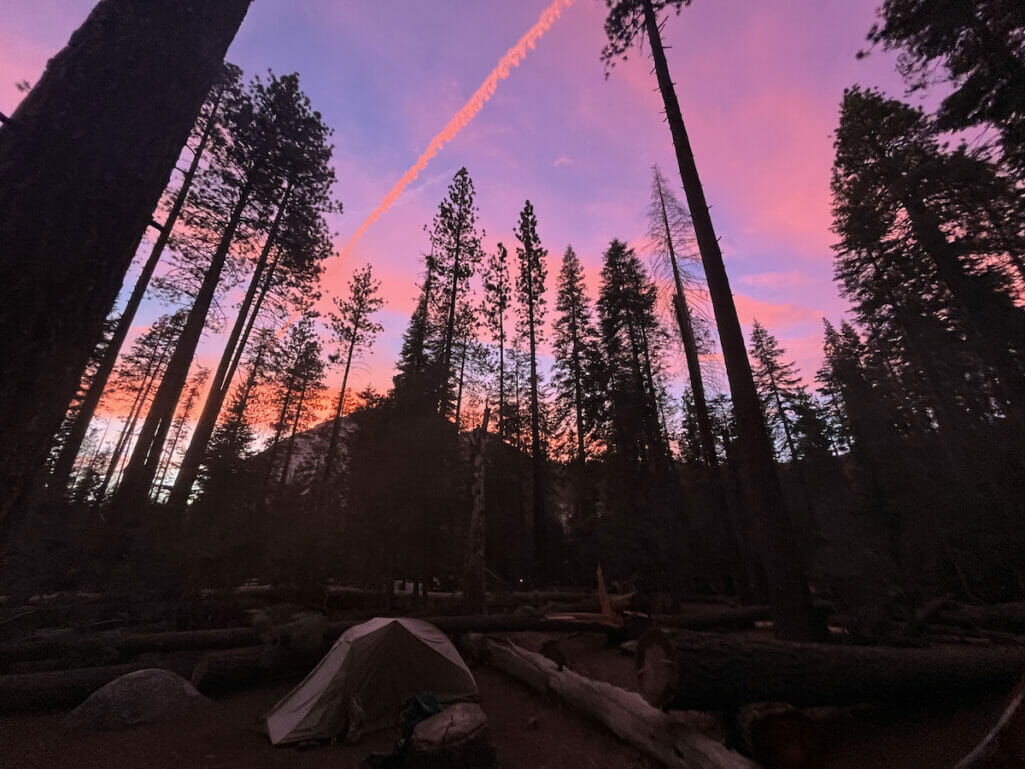 A pink and blue sky over Little Yosemite Valley with tents in the foreground.