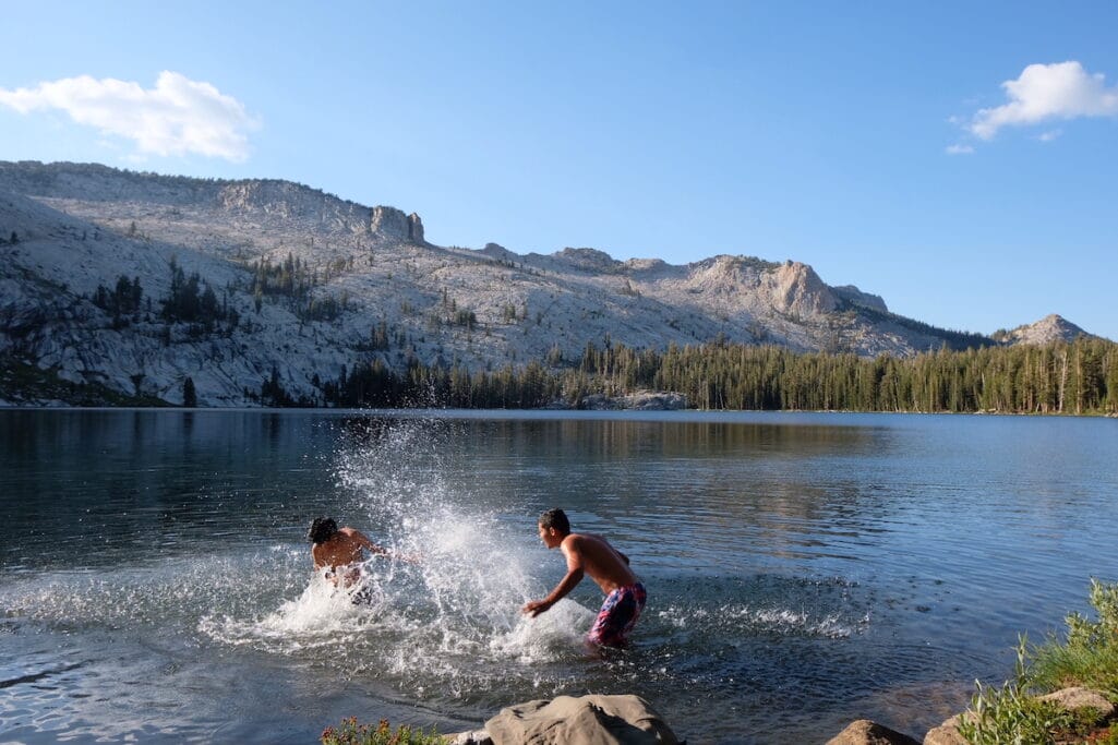 Two kids splashing water in a lake.