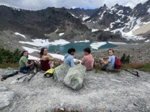 Kids looking back in front of a blue lake and mountains in Olympic National Park