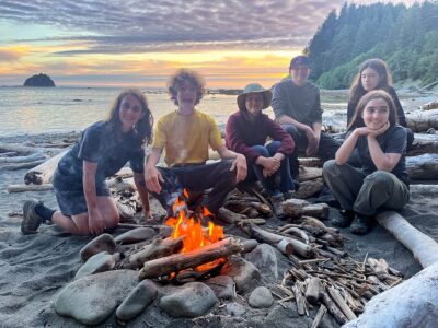 A group of teens around a fire in Olympic National Park