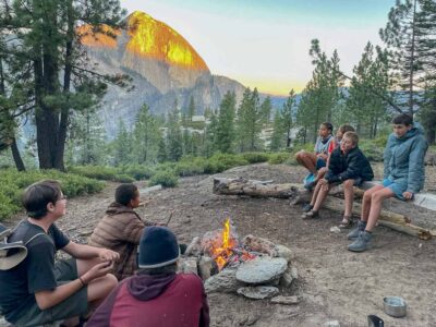Sitting by the fire during our outdoor summer camp for kids in Yosemite