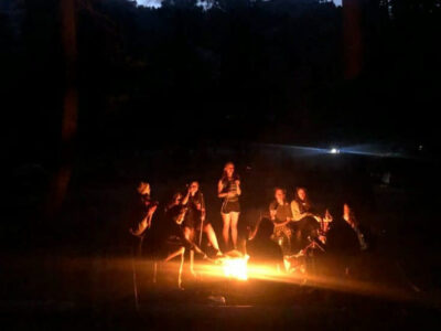 sitting around the fire on a california adventure outdoor summer camp