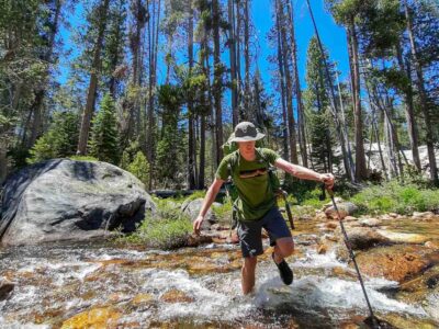 fording a river on a backpacking summer camp adventure