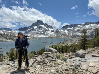 Teen backpacker smiling in front of Thousand Island Lake and Mt Banner
