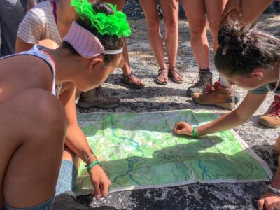 young women studying the map on one of our outdoor adventure summer camps